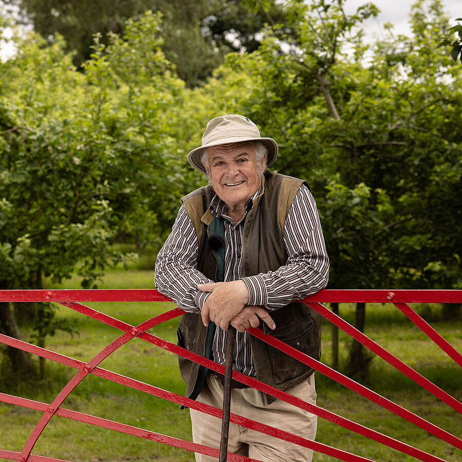 Rod leaning on Sunburst gate - Highbank Orchards Self-Guided 'Red Gate' Walk