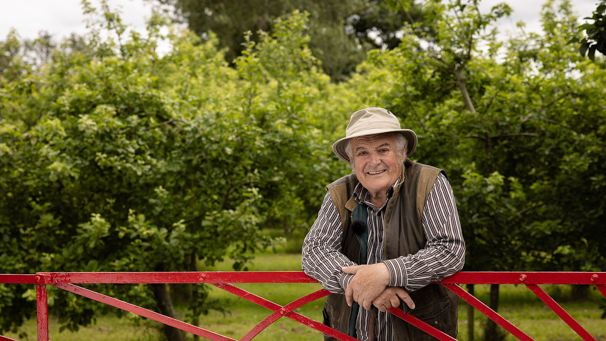 Rod leaning on Sunburst gate - Highbank Orchards Self-Guided 'Red Gate' Walk