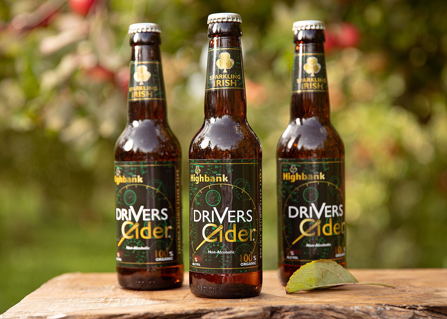 3 bottles of Drivers Cider on wood in the orchards.