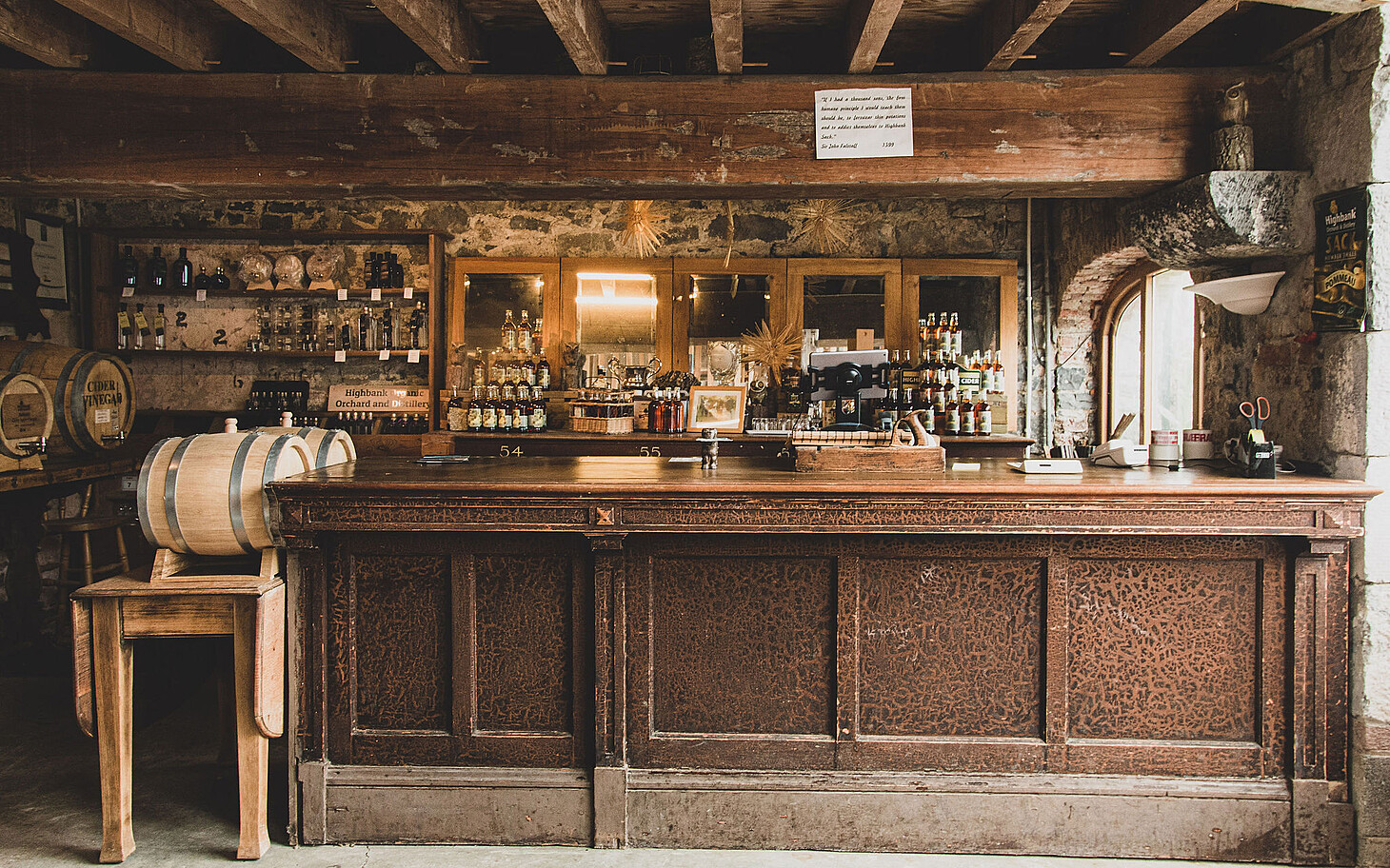 Highbank Orchards farm shop with traditional counter. Barrels of product and shelves stacked with Highbank bottles.