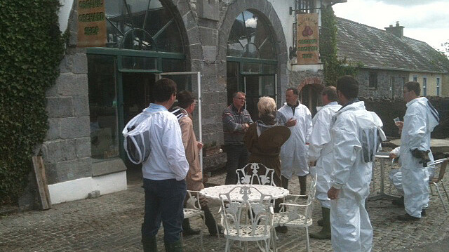 group of bee keepers in white protective suits outside farm shop