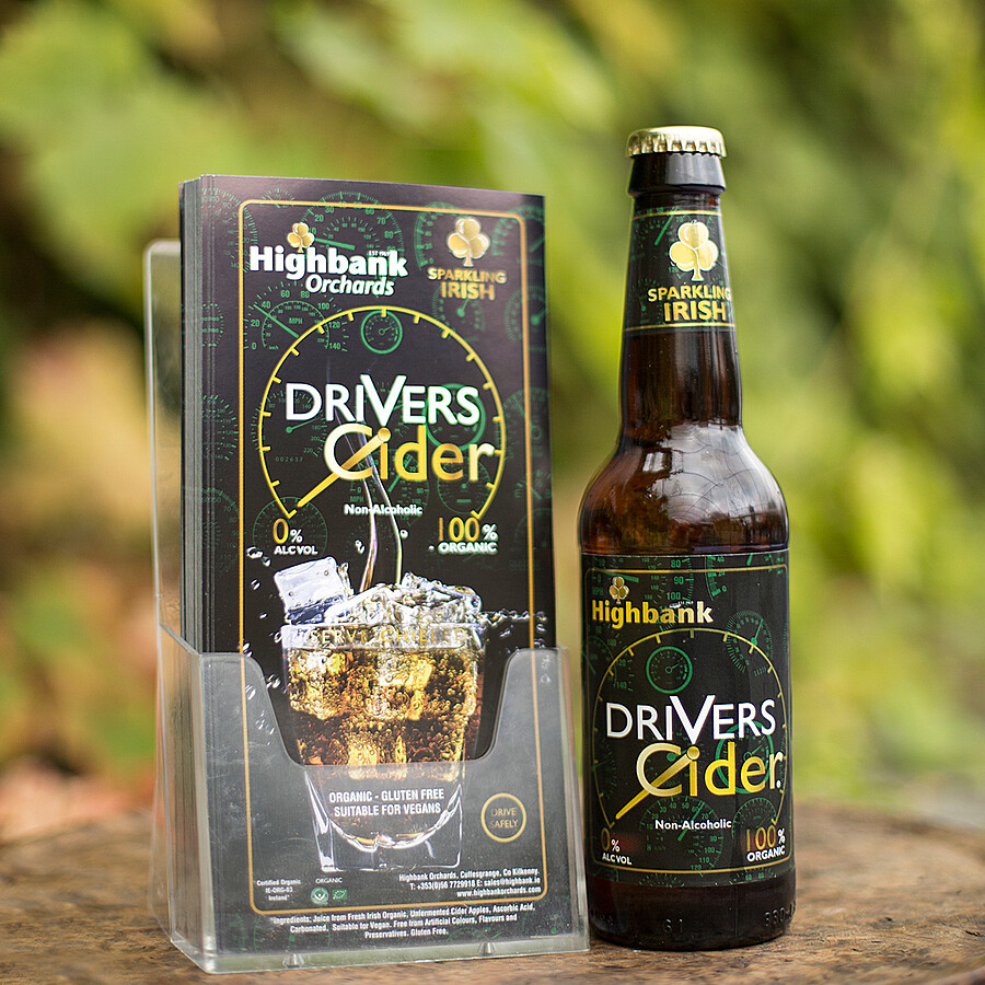 An image of a single bottle of drivers cider beside a packet of leaflets with a picture of a drink of drivers cider with ice.