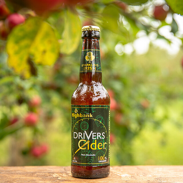 Single bottle of Drivers Cider on wooden block in Orchard