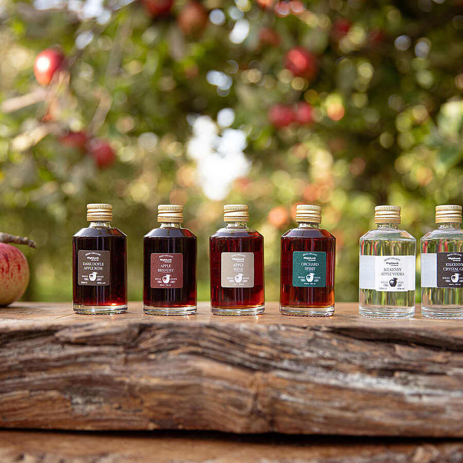 6 x 50ml organic miniature glass bottles on wood in the orchards.  Highbank Apple Brandey, Highbank  Apple Rum, Highbank  Apple Wine, Highbank Orchard Spirit, Highbank Apple Gin