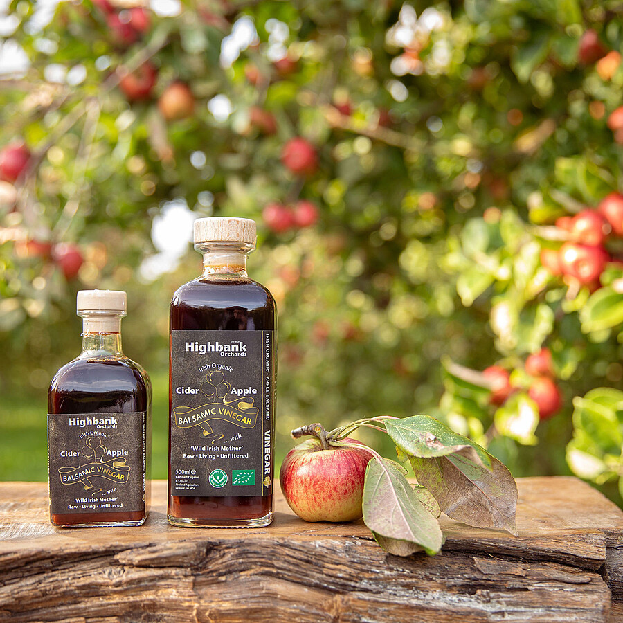 2 square glass bottles of balsamic vinegar on wood in the orchards. 250ml and 500ml sizes.