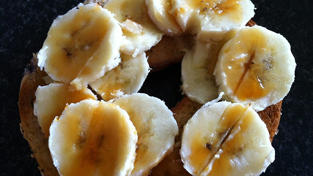 bagel with sliced bananas drizzled in orchard syrup on top