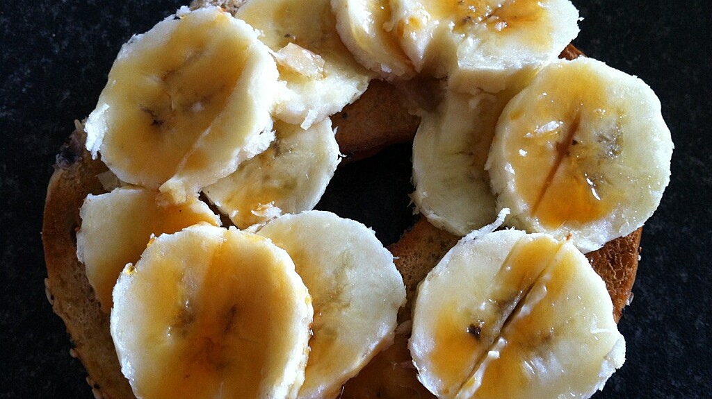 bagel with sliced bananas drizzled in orchard syrup on top